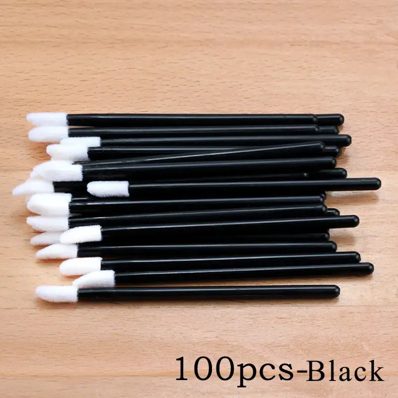 Black lip gloss applicators with white tips.