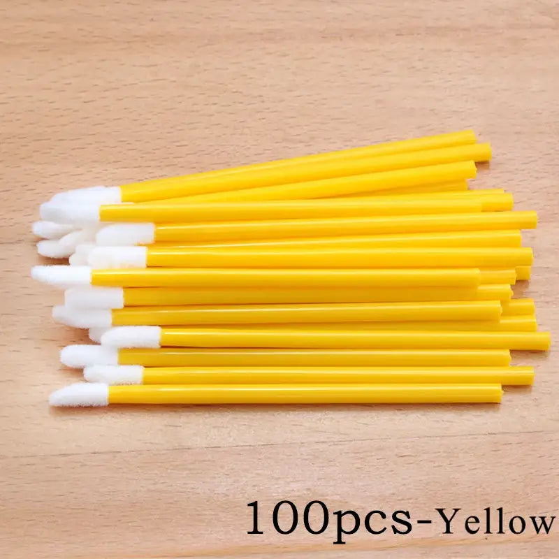 Yellow disposable lip brushes.
