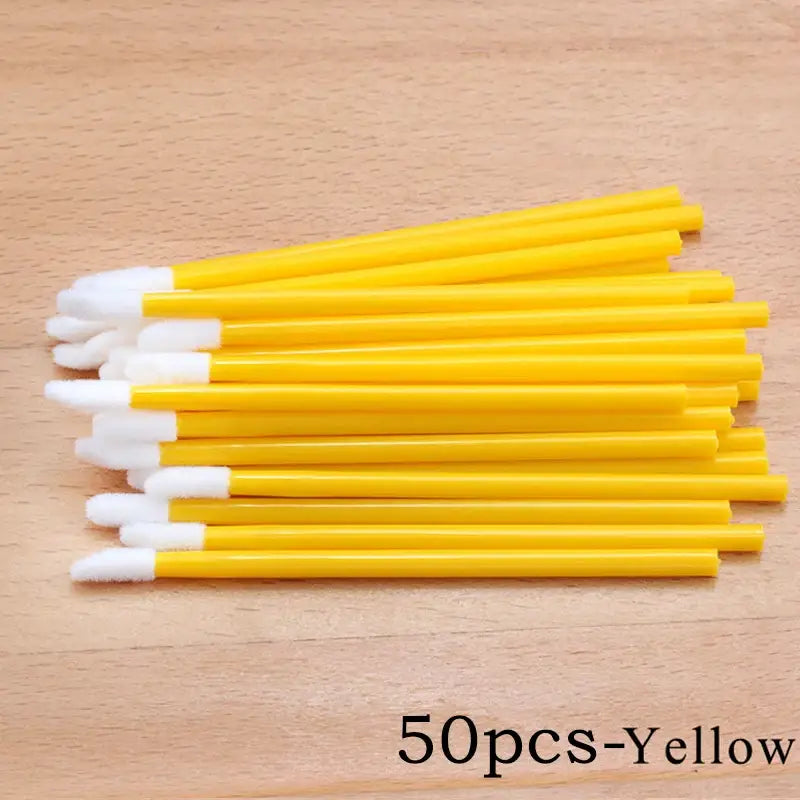 Yellow lip brushes with white cotton tips.