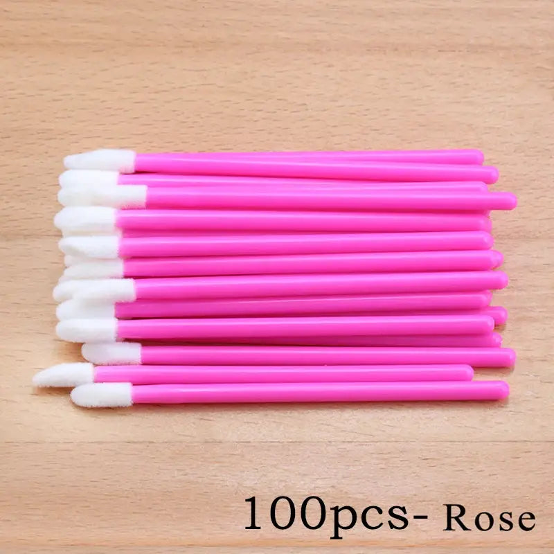 Pile of pink lip gloss applicators.