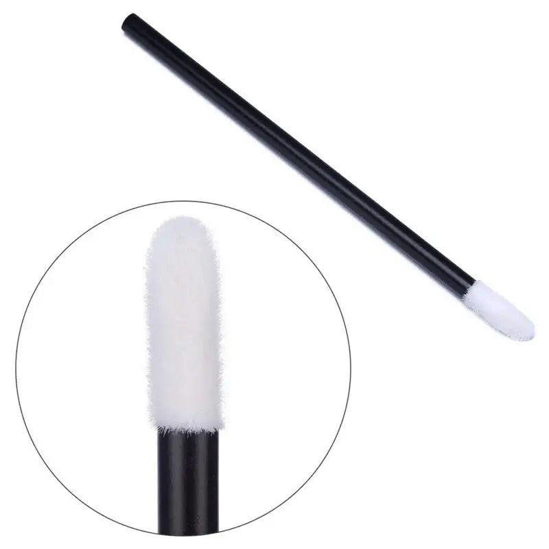 Black lip gloss applicator with white sponge tip.