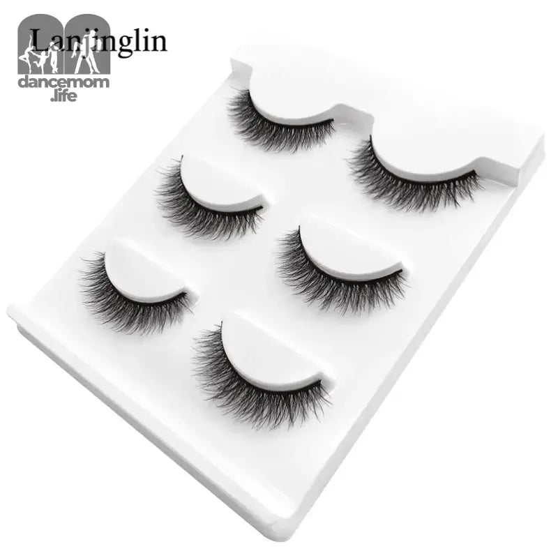 Five pairs of false eyelashes on a white plastic tray.