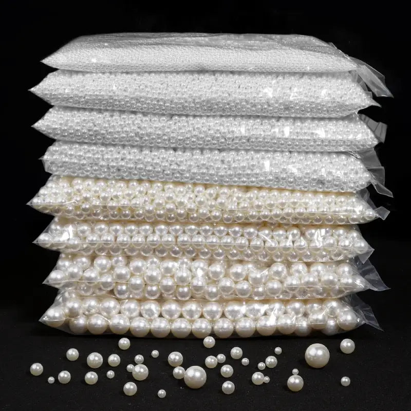 Stacks of plastic bags containing white and cream-colored pearls.