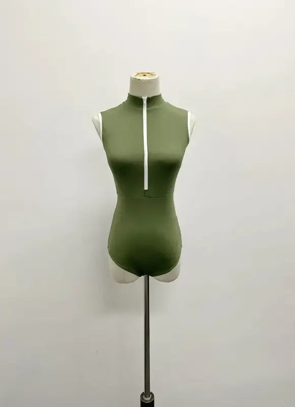 Olive green sleeveless bodysuit with white zipper detail on mannequin form.