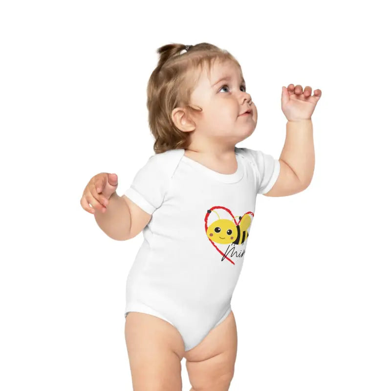 White baby onesie with a cute bee and heart design.