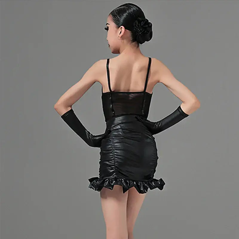Black ruched mini dress with spaghetti straps, long gloves, and a ruffled hem.