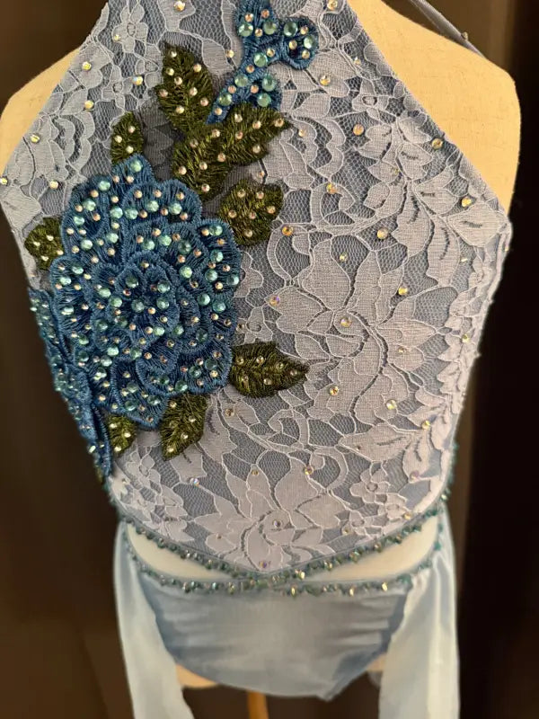 Blue lace dance costume with floral embellishments.