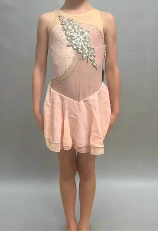 Pale pink figure skating dress with sheer panels and crystal embellishments.