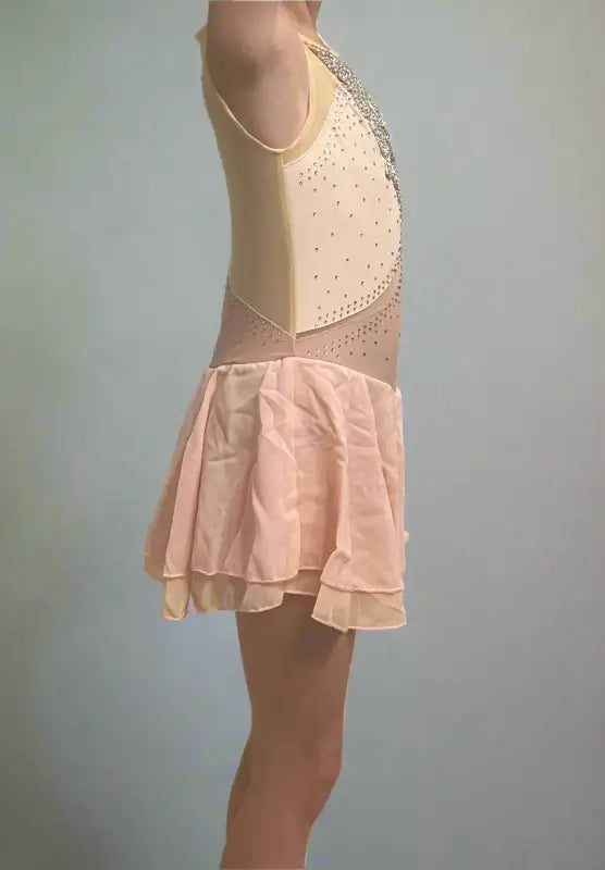 Figure skating dress with a beige bodice and pale pink skirt.