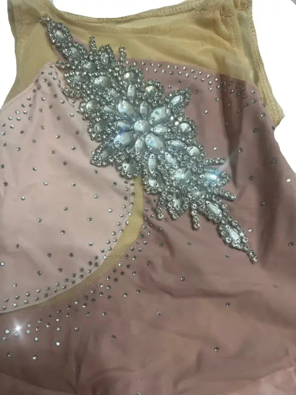 Embellished leotard or dance costume with sparkly floral appliqué and rhinestones.