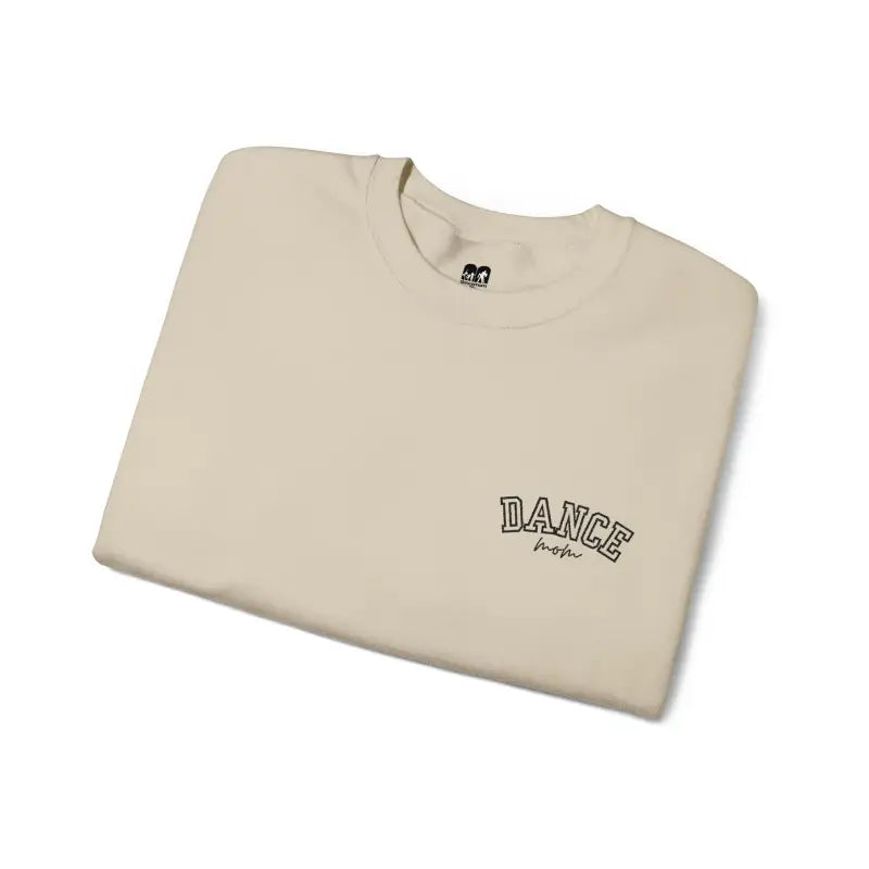 Folded beige t-shirt with ’DANCE’ text printed on the chest.