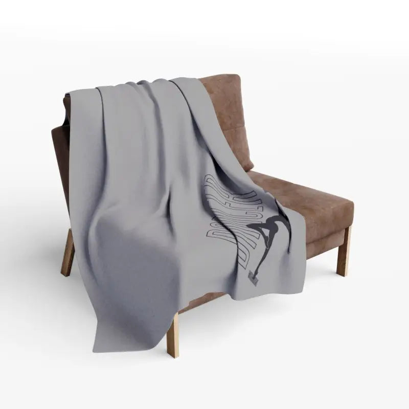 Gray throw blanket with a butterfly design draped over a brown chair.