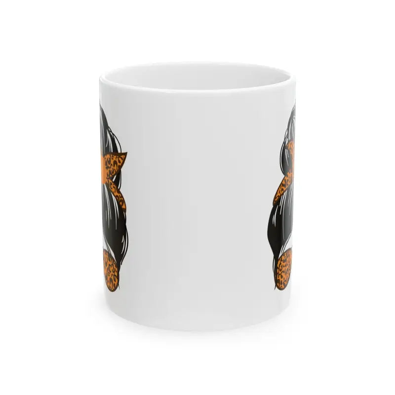 White ceramic mug with black and orange cat designs on its surface.