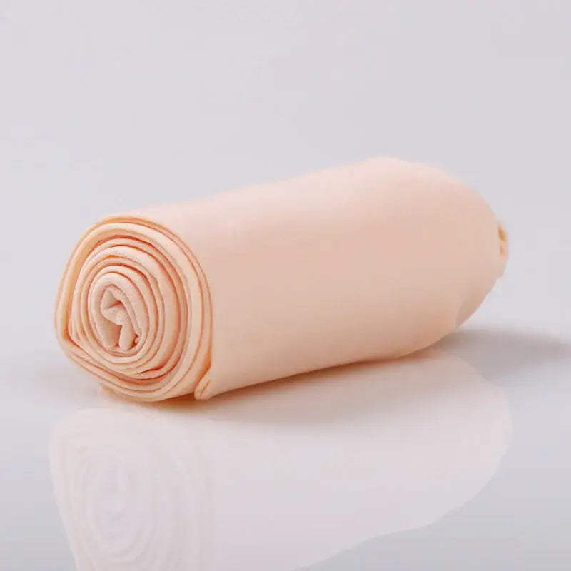Rolled peach-colored fabric or textile material with visible spiral layers.