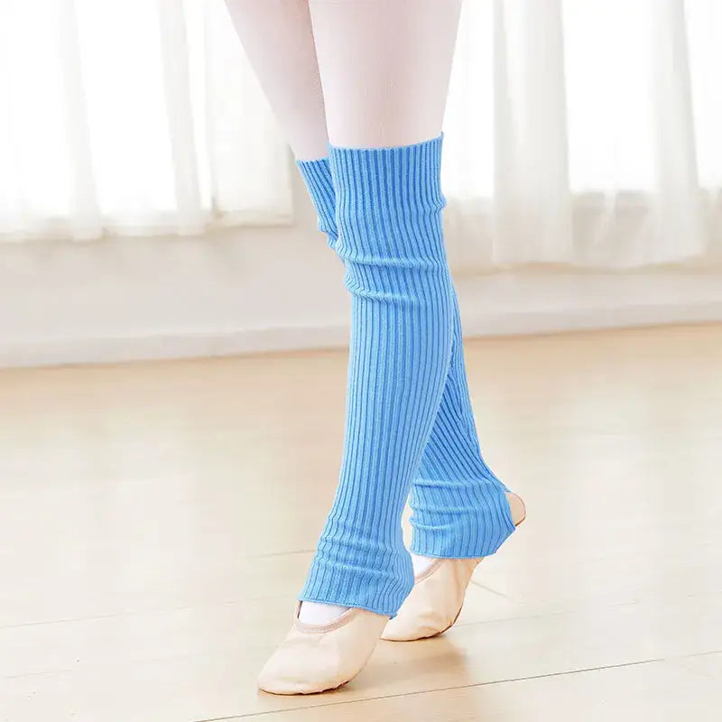 Light blue knitted leg warmers worn over ballet shoes.