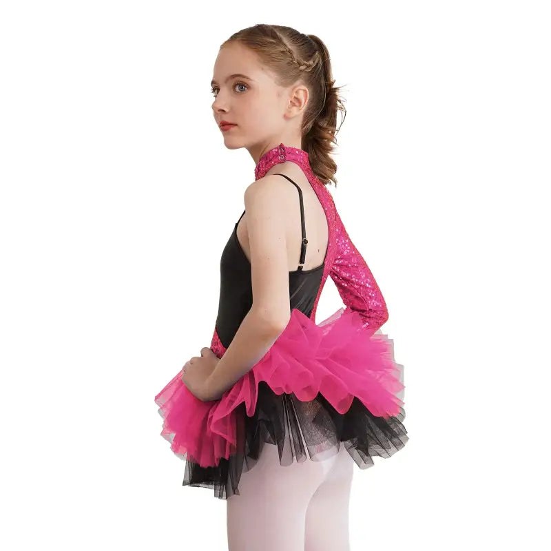 A dancer wearing a pink and black tutu dress with white tights in a ballet pose.