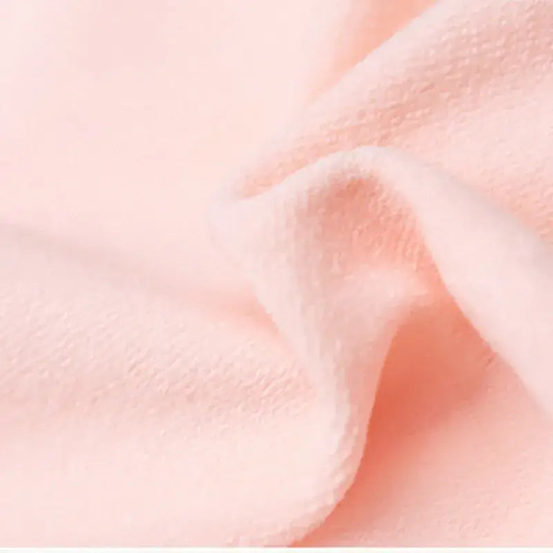 Soft pink fabric with gentle folds and creases.