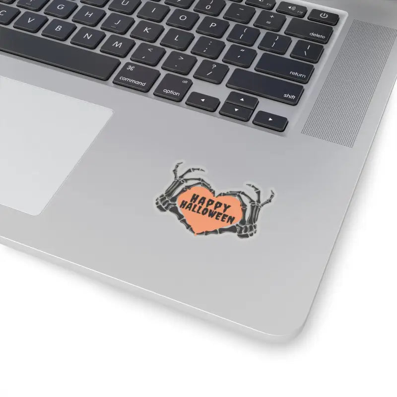 ’Happy Halloween’ sticker with skeleton hands on a laptop.