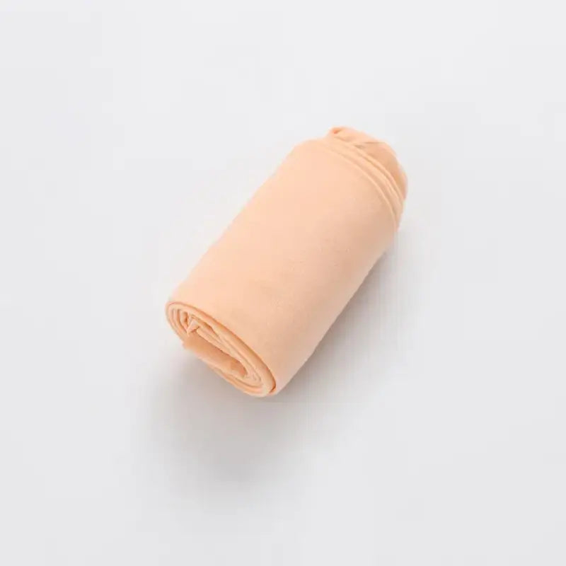 Rolled-up peach-colored fabric or textile material.