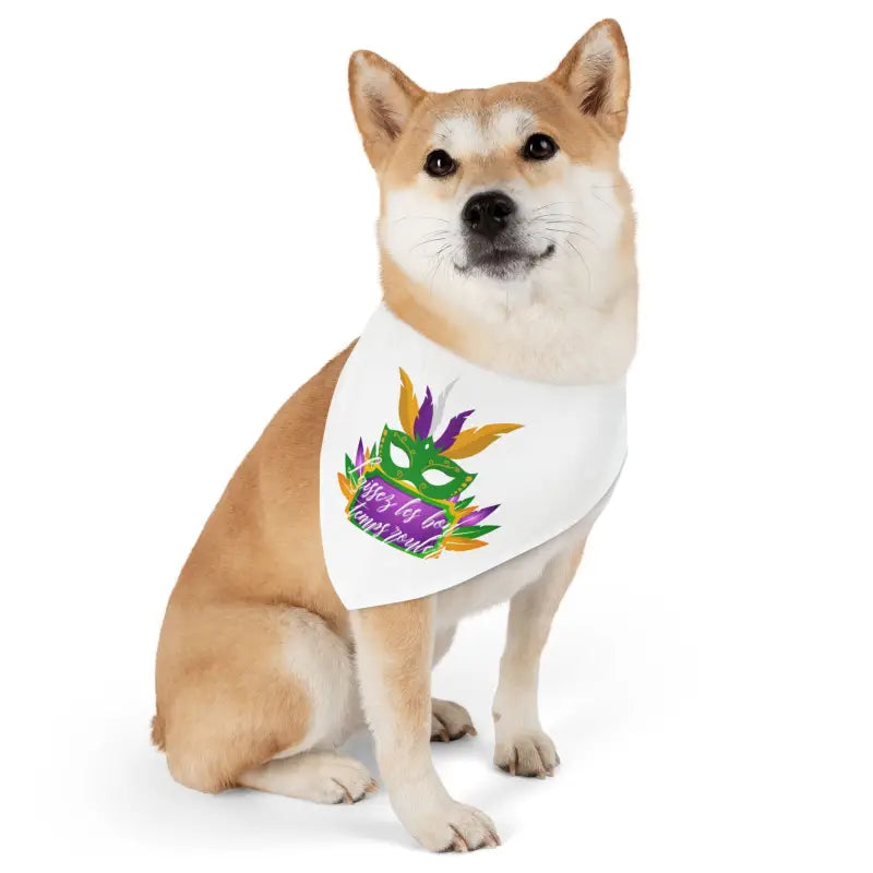 Shiba Inu dog wearing a white bandana with a colorful Mardi Gras mask design.