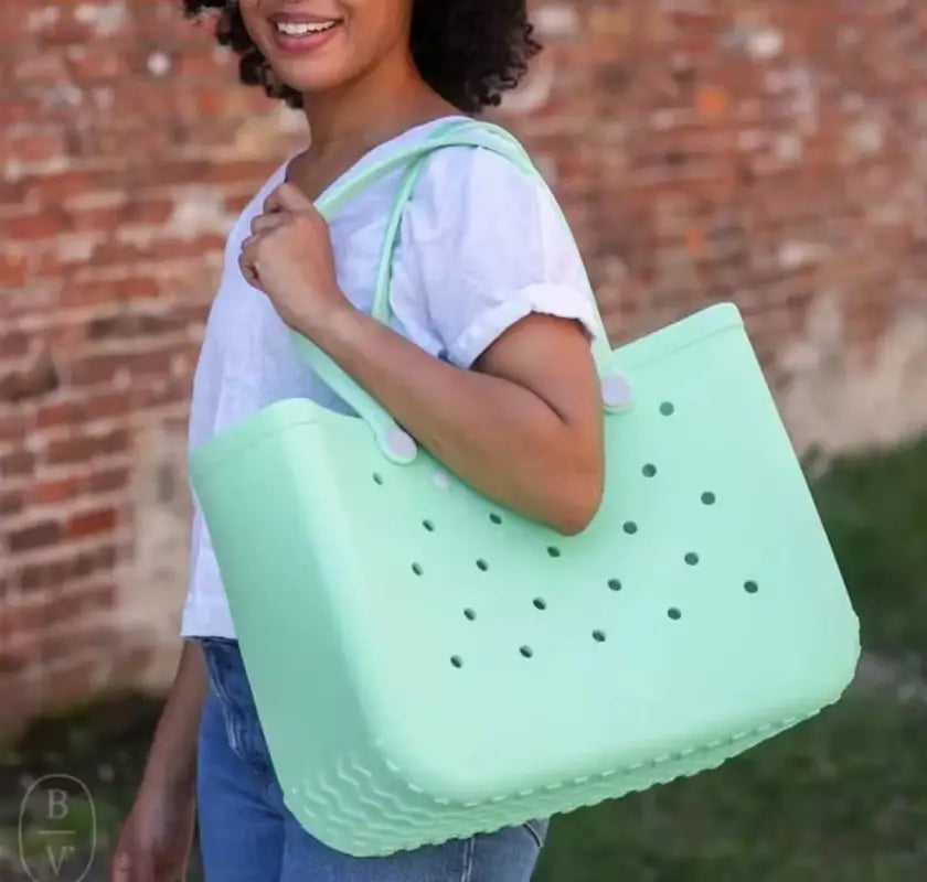 Mint green tote bag with holes.