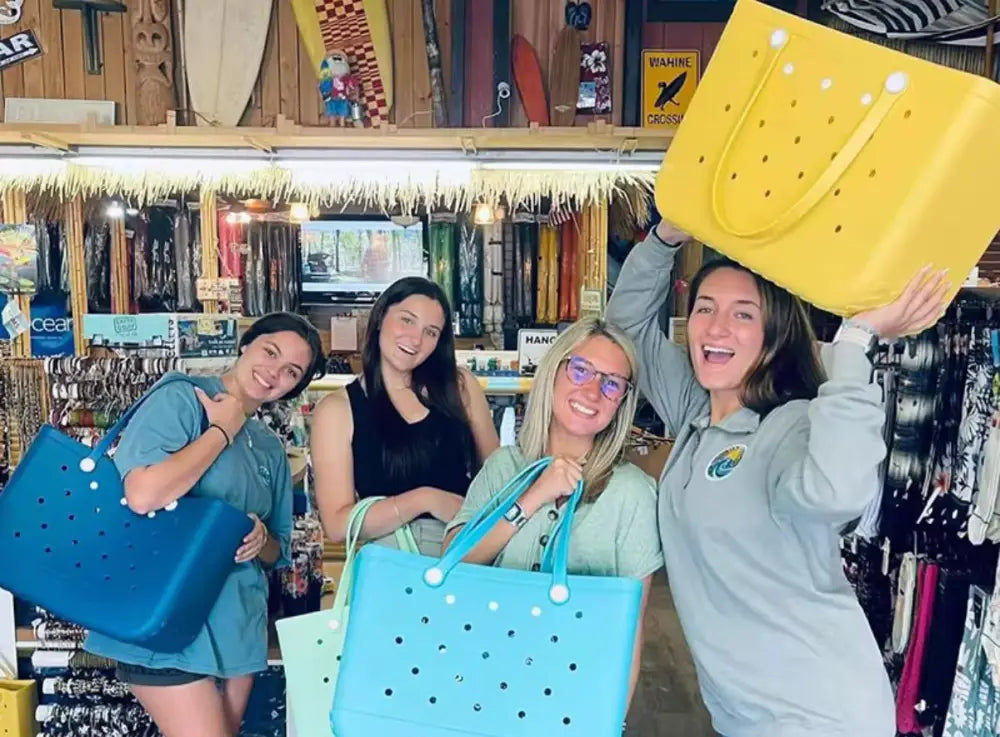Four women holding colorful tote bags.