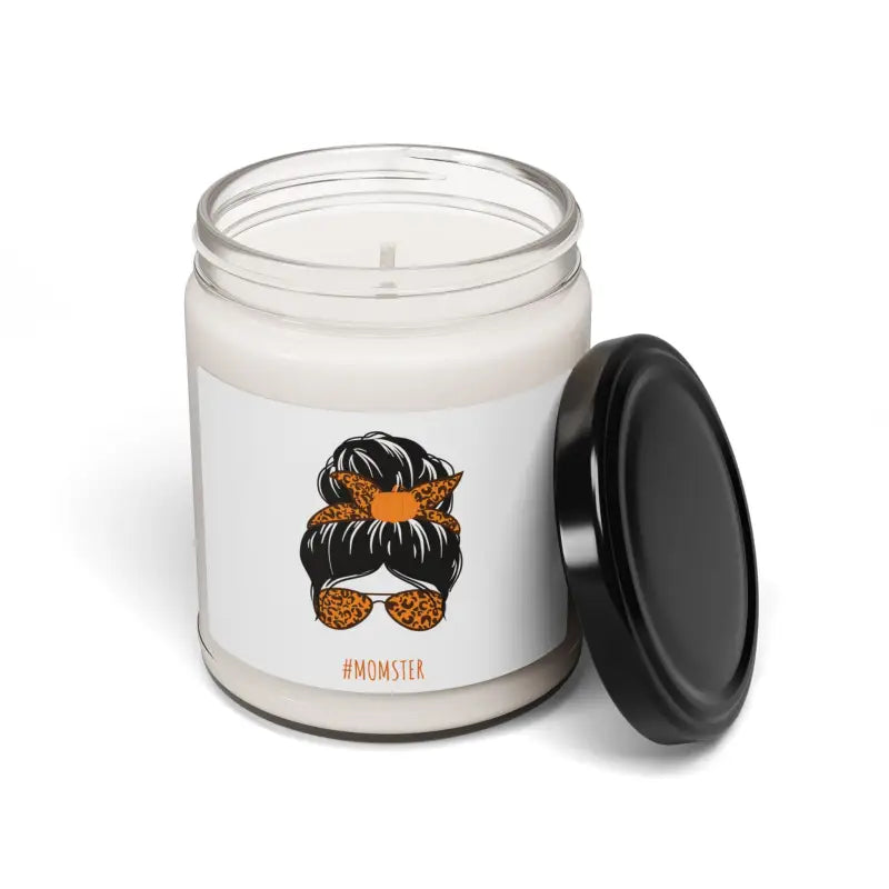 White candle in a glass jar with a black lid and an illustration of a messy bun hairstyle with sunglasses and orange bandana on the label.