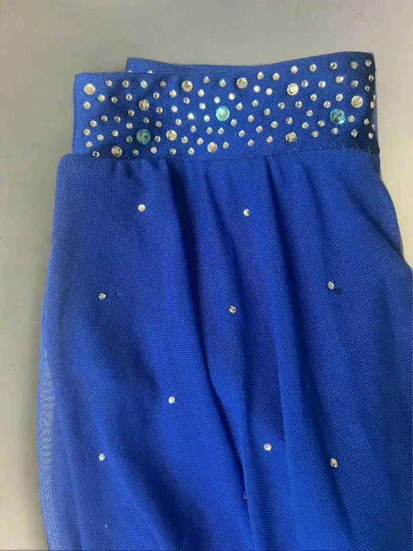 Blue fabric garment with silver studded embellishments along the waistband and scattered across the body.