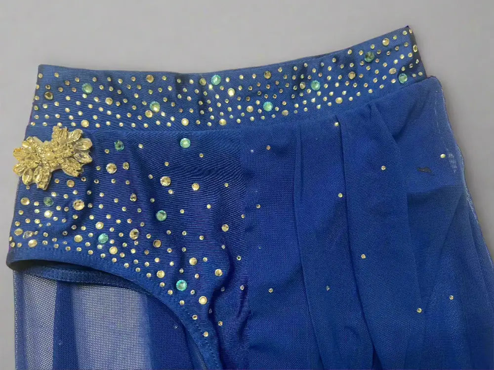 Blue dance skirt with sparkly gold accents and a mesh overlay.