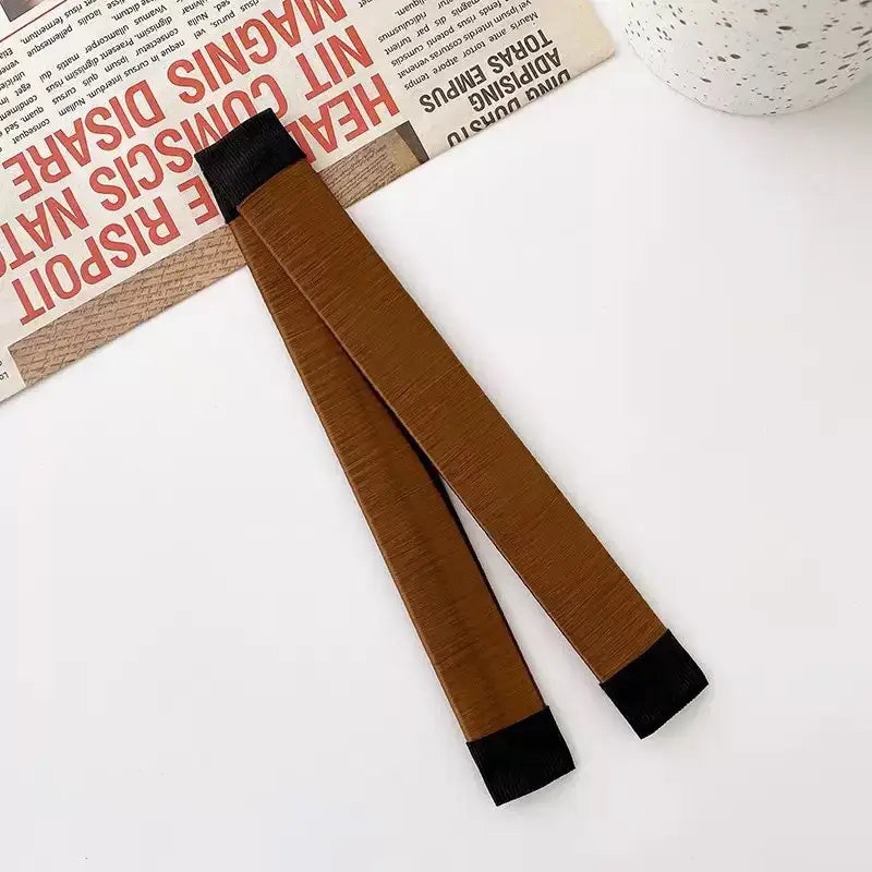 Brown hair styling tool with black ends.