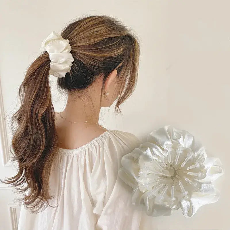 White silk scrunchie worn in a ponytail hairstyle.