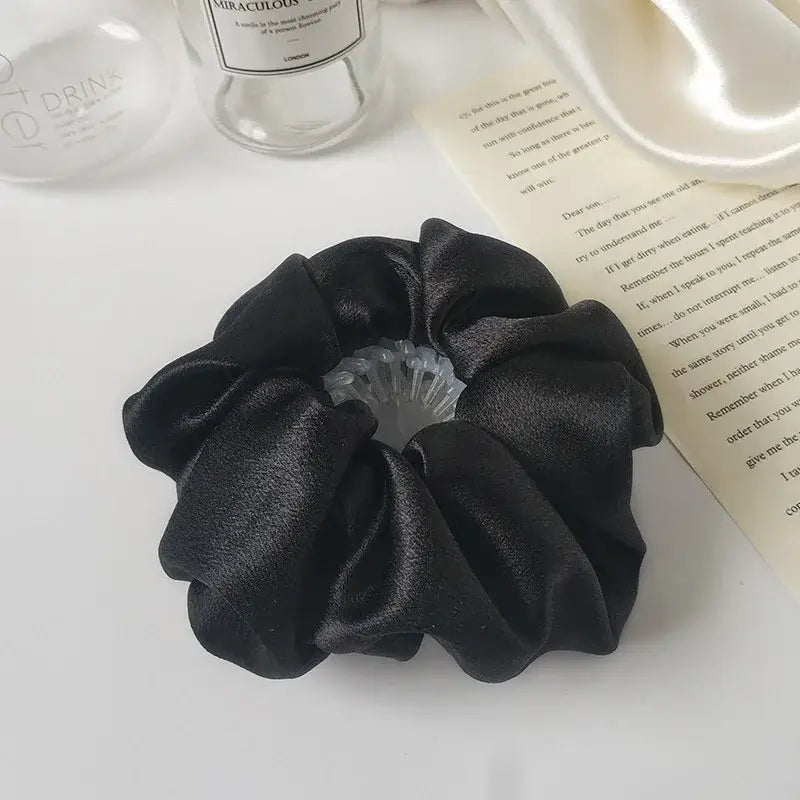 Black satin scrunchie with a pleated flower design.