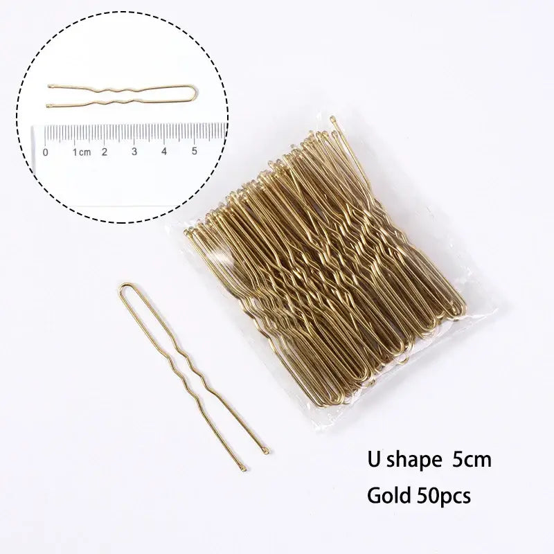 Gold-colored U-shaped hair pins packaged in a clear plastic bag.