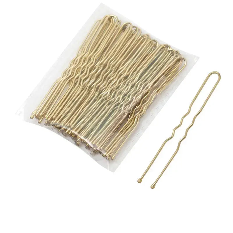 Gold-colored metal hair pins with a wavy U-shape design.