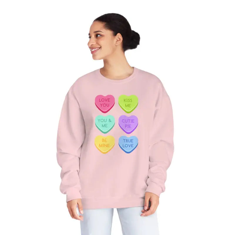 Pink sweatshirt featuring colorful candy heart designs with text.