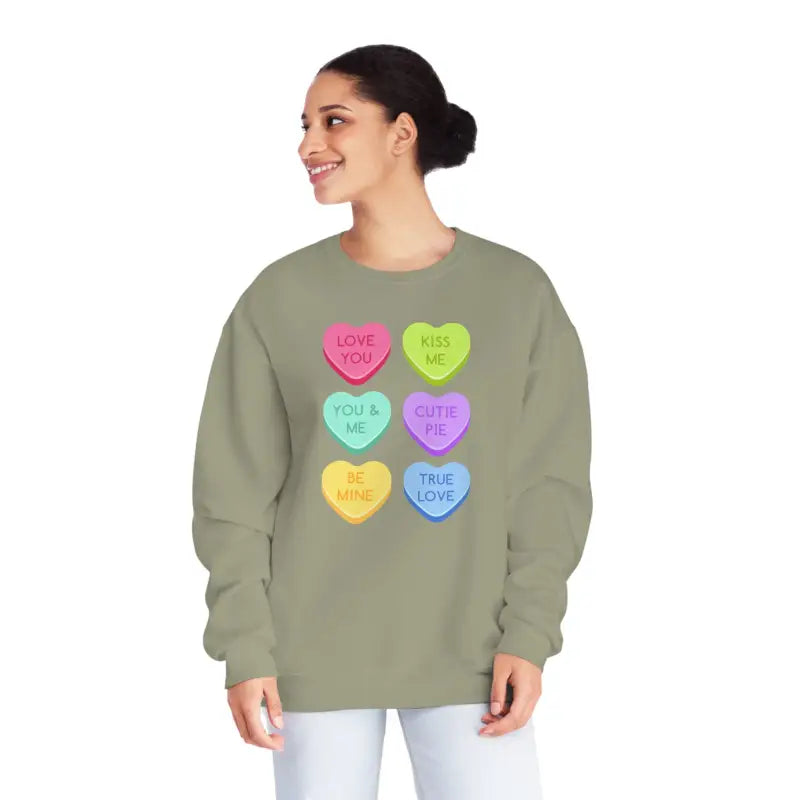 Sage green sweatshirt featuring colorful candy heart designs with messages printed on them.