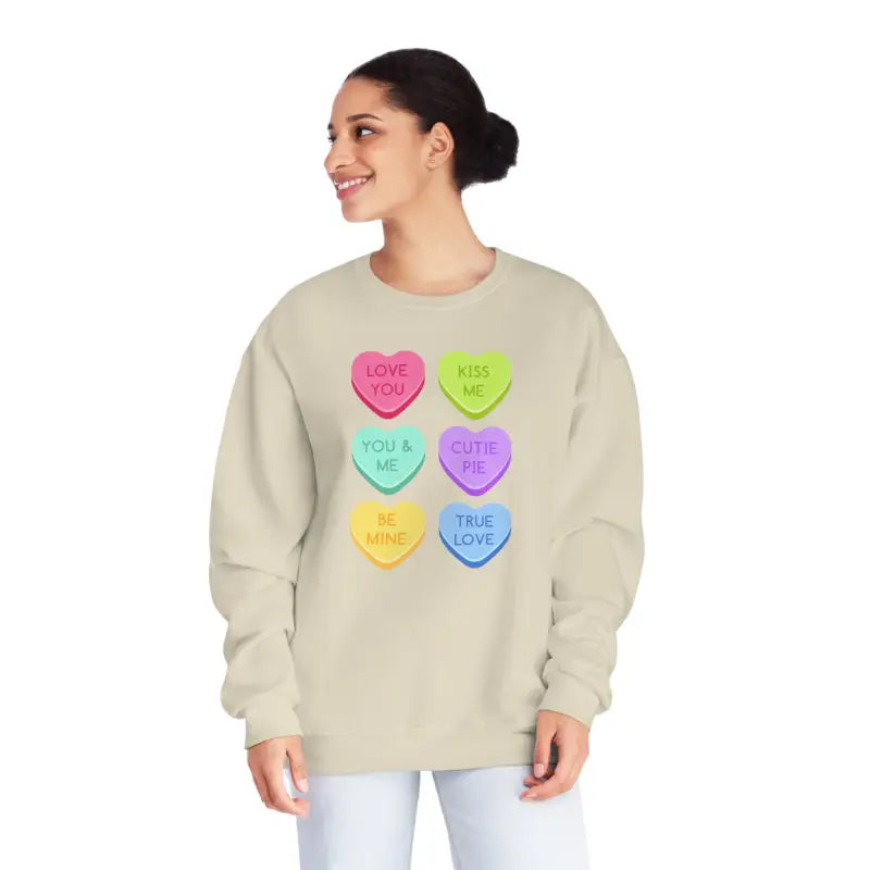 Beige sweatshirt featuring colorful candy heart designs with messages printed on them.