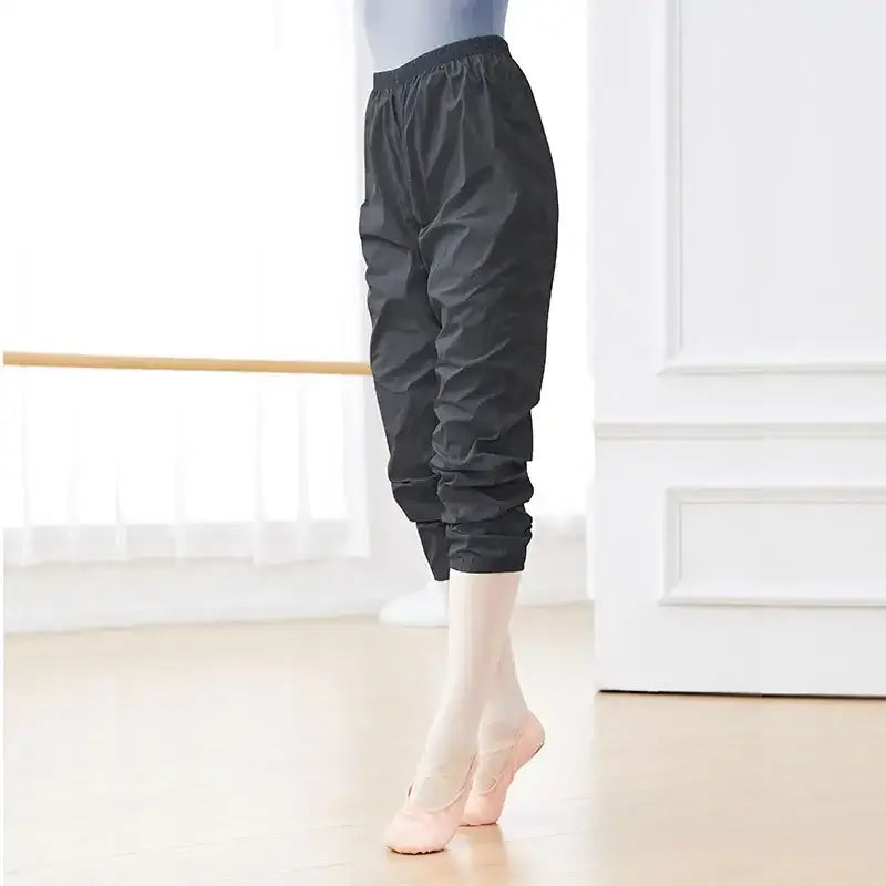 Black cropped dance warm-up pants with elastic cuffs.