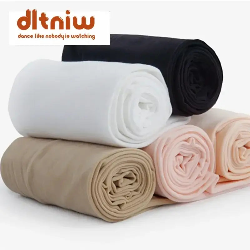 Rolled fabric pieces in white, black, beige, and pink colors.