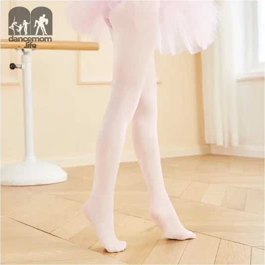 White ballet tights on legs in first position.