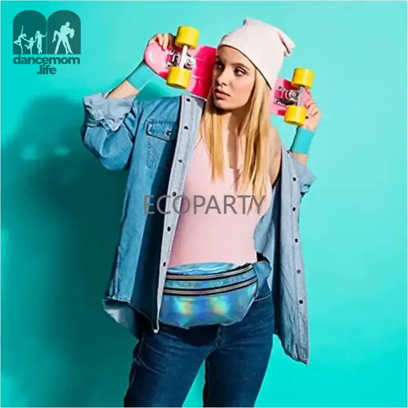 A skater in a denim jacket, pink beanie and fanny pack holding yellow skateboards against a turquoise backdrop.