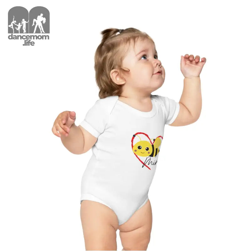 White baby onesie with a cute bee and heart design.