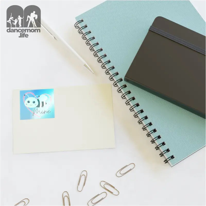 Spiral-bound notebook with a mint green cover and scattered paper clips.