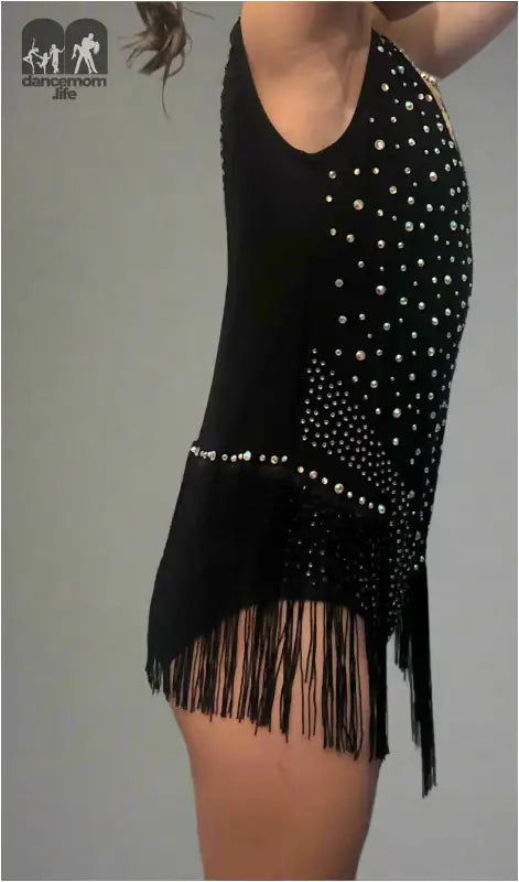 Black fringed dress with white polka dot pattern and asymmetrical design.