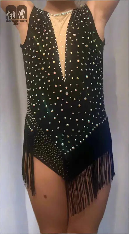 Sparkly black bodysuit with fringe and a plunging neckline adorned with rhinestones.