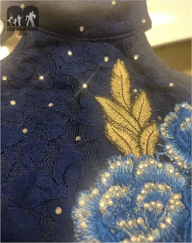 Navy blue garment with embroidered floral designs and polka dots.