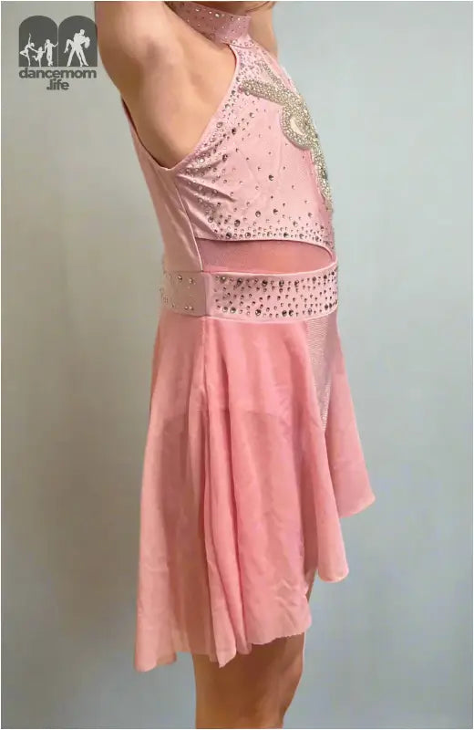 Pink figure skating dress with sparkly embellishments and a flared skirt.