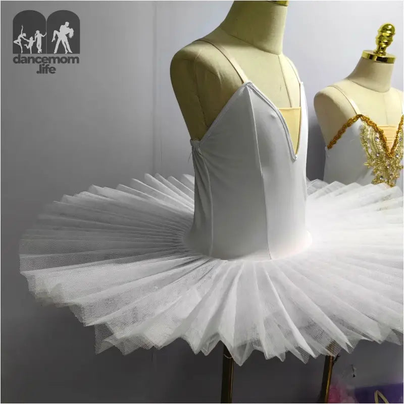 White classical ballet tutu with spaghetti straps displayed on a dress form.