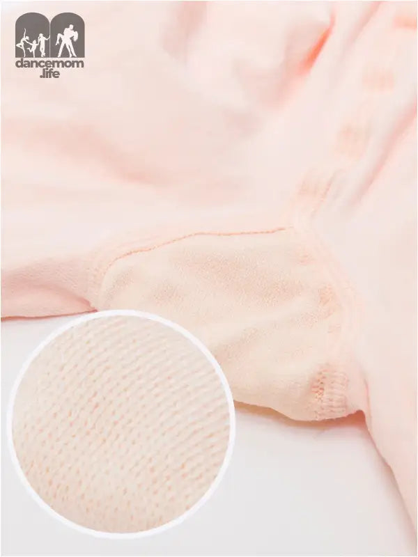 Soft pink fabric with a magnified circular detail showing its textured weave pattern.