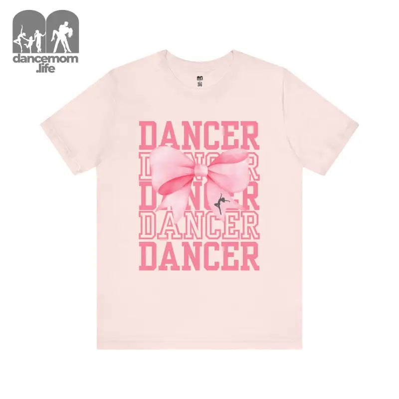 Pink t-shirt with ’DANCER’ text and bow design printed in coral pink.